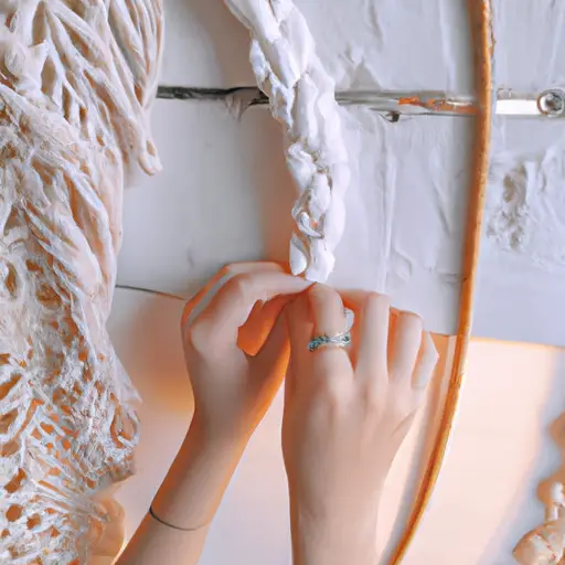 an image of delicate hands adorned with dainty gold rings, gently weaving a macramé wall hanging