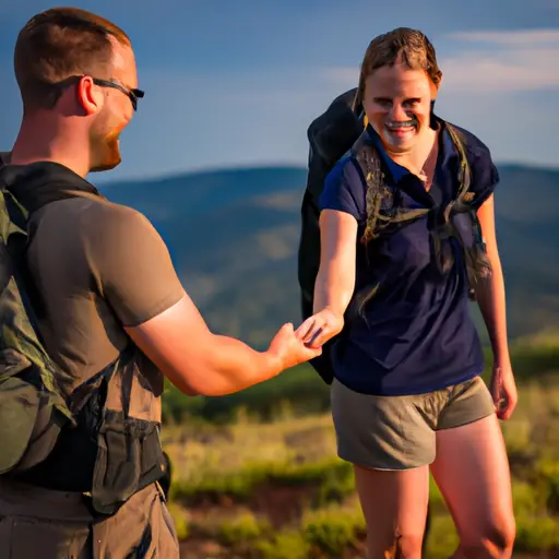 An image showcasing a couple hiking together in lush green mountains, with beaming smiles, as they hold hands and share a passionate moment, highlighting the benefits of having similar activities in a relationship